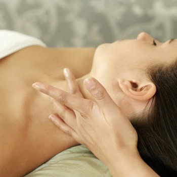 A person enjoying a soothing neck massage combined with a hot stone treatment while lying on their back in Ottawa, Swedish Relaxation Massage